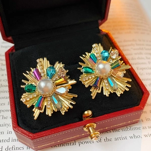 Macro detail of vintage floral earring with pearls and multicolor crystals in a red jewelry box