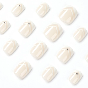 Kurze beige Press-on-Fußnägel mit weißen V-Linien und glitzernden Strasssteinen
