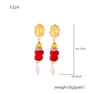 Detail view of gold ring earrings with red beads and white pearls, sized 4.7cm x 0.9cm