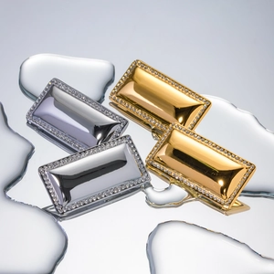 Detailed view of gold and silver rectangular earrings with micro-inlaid rhinestones