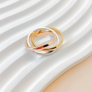 Macro shot of interlocking tricolor bands in white, yellow, and rose gold finishes