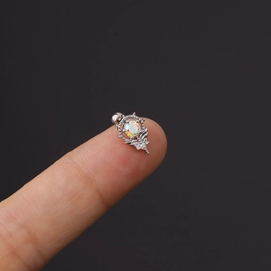 Detailaufnahme von Silber-Tragus-Piercing mit irisierendem Zirkon und Flügeldesign