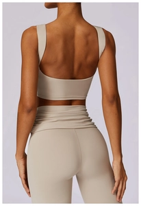 Detail of cross-waist yoga leggings and U-back sports bra set in beige high-elastic fabric