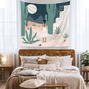 Close-up of bohemian tapestry showing woman in desert night scene above a bed