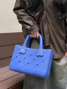 Dettaglio della borsa da spiaggia blu in EVA con motivi geometrici e ciondolo a fiore