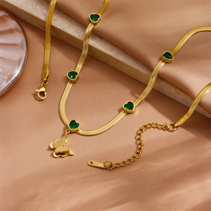 Collier chaîne serpent dorée avec cœurs verts et pendentif papillon sur soie beige