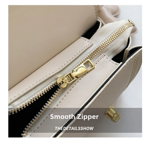 Dettaglio borsa in pelle beige con cerniera in metallo dorato di alta qualità e liscio