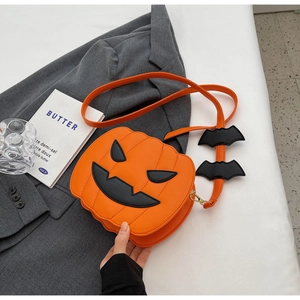 Detailed view of pumpkin cross body bag with black bat wing charms on the strap