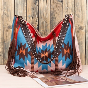 Detail of bohemian hand-woven patterns with brown leather fringe on large tote bag