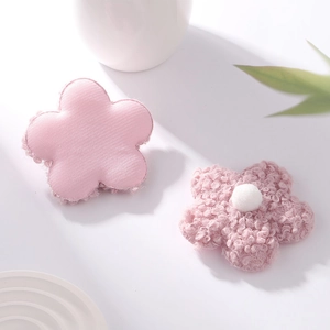 Detailed view of pink teddy velvet and silk fabric flower accessories with white centers