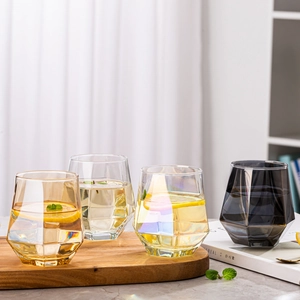 Detailed view of hexagonal geometric glass cups with lemon slices in a lifestyle setting