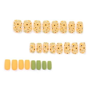 Short square press-on nails with yellow floral patterns and matte orange-green colors