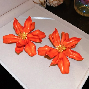 Detail shot of orange acrylic flower earrings with crystal centers in a jewelry box