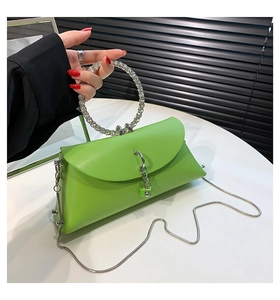 Detail of neon green handbag with rhinestone-encrusted ring handle and silver chain