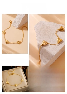 Detail of gold chain bracelet featuring 3D heart charms and adjustable lobster clasp