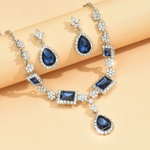 Detail of blue teardrop pendant necklace and earrings set with crystal pavé accents