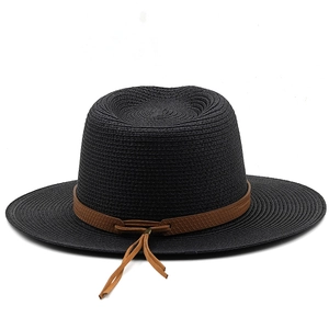 Detail of black straw boater hat with a brown leather decorative band and woven texture