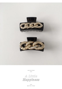 Detail of square hair claws featuring vintage metal chain designs on black bases