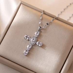 Sparkling silver cross pendant necklace with clear zircon stones on jewelry box