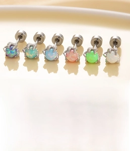 Macro detail of silver titanium dragon claw stud earrings with colorful opal inlay