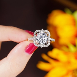 Close-up van fonkelende diamanten bloemring met klavervormige halo en pavé