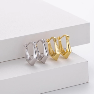 Macro shot of minimalist silver and gold U-shaped S925 sterling silver hoop earrings