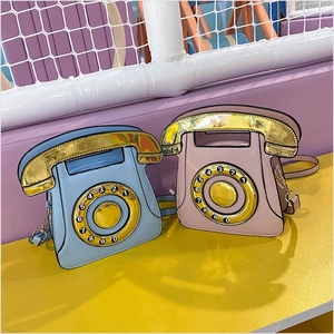 Retro telephone shaped crossbody bag in blue and pink with a vintage rotary dial design