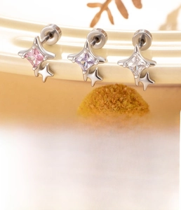 Macro view of titanium steel star stud earrings with pink and purple zircon stones