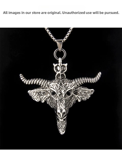 Close-up of vintage steel bull head pendant with pentagram engraving on black background