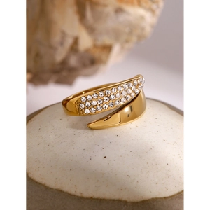 Detailed macro view of 18k gold bypass ring featuring shimmering cubic zirconia accents
