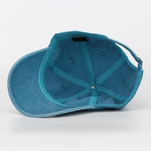 Inside detail of a teal washed canvas baseball cap showing stitching and inner tape