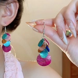 Détail de boucles d'oreilles pendantes en résine aux couleurs vives rose et bleu sarcelle