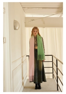 Close-up of pink and green gradient wool scarf with soft tassels and plush texture