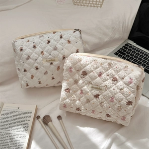 Detailed view of quilted cotton cosmetic bags with cute bear and heart prints and zipper