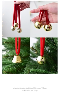 Detail of metal Christmas bells with red velvet ribbons on a festive tree branch