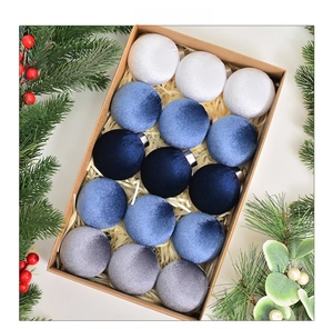 Close-up of 15 velvet Christmas ball ornaments in blue and white in a kraft gift box