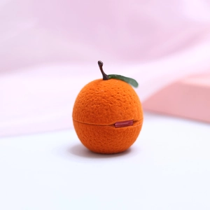 Detailed view of the orange fruit-shaped jewelry box featuring soft velvet texture