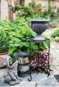 Dettaglio di un supporto per piante in ghisa vintage con decorazioni in un giardino esterno