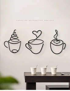 Three-piece black metal coffee cup wall art set featuring minimalist wire line designs