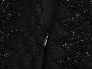 Close-up of invisible zipper and sequined textured fabric on black evening dress