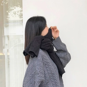 Close-up of a premium black knit winter scarf with soft wool-like texture and thick weave