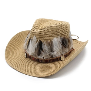 Khaki straw cowboy hat with authentic feathers and vintage metal pendants on white background
