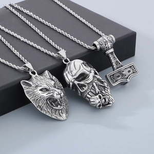 Detailed shot of punk stainless steel wolf head, skull, and Mjolnir hammer pendants