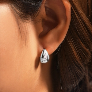 Close-up of 925 sterling silver teardrop stud earring with clear crystal on model