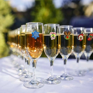 Christmas silicone wine glass markers with snowflake and Santa shapes on a champagne glass