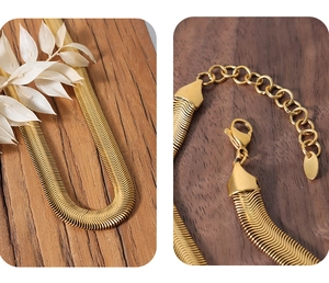 Detail view of flat gold-plated snake chain necklace with lobster clasp and extension link