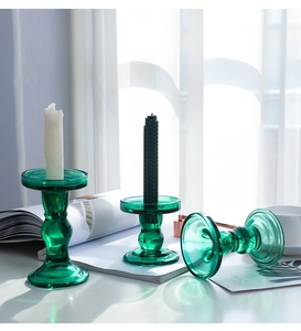 Macro detail of emerald green glass candle holders with elegant ribbed Roman column textures