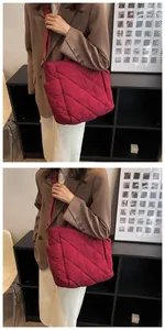 Detail of burgundy quilted tote bag with diamond pattern and adjustable shoulder strap