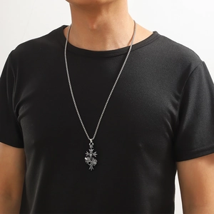 Gros plan d'un pendentif croix vintage en argent avec couronne et coeur sur un mannequin