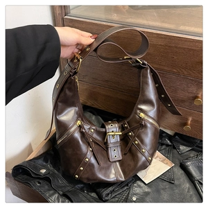 Detail of dark brown hobo bag with gold hardware, rivets, and adjustable leather strap